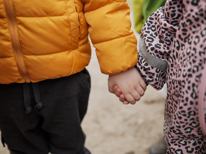 Zwei Kinder laufen Hand in Hand